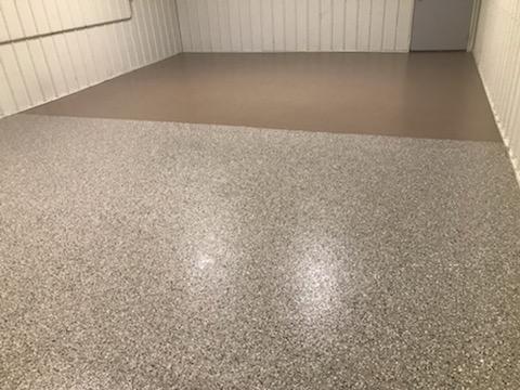 A rectangular basement room is finished with two types of concrete flooring