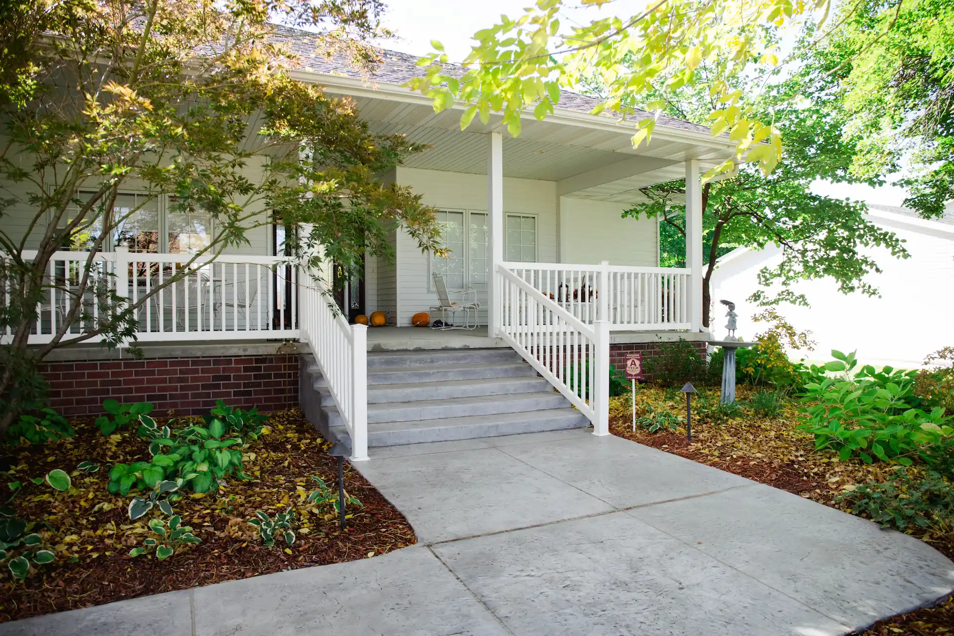 A concrete walkway connects to a concrete porch and stairs of an Iowa home. A new concrete walkway, porch, and stairs are just a few ways you can enhance your home's curb appeal.
